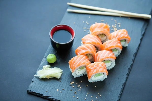 Filadelfia rotolo classico su uno sfondo di pietra scura. Formaggio Philadelphia, cetriolo, avocado. Sushi giapponese. Vista dall'alto — Foto Stock