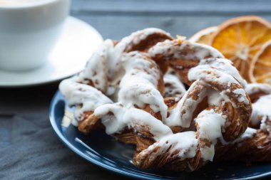 Ezilmiş fındık ve limon fondan mavi tabakta ile Bavyera kremalı pasta. Arka planda bir fincan çay ve kurutulmuş Portakal dilim