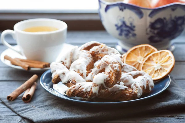 Ezilmiş fındık ve limon fondan mavi tabakta ile Bavyera kremalı pasta. Arka plan, tarçın ile yeşil çay ve bir aranjman