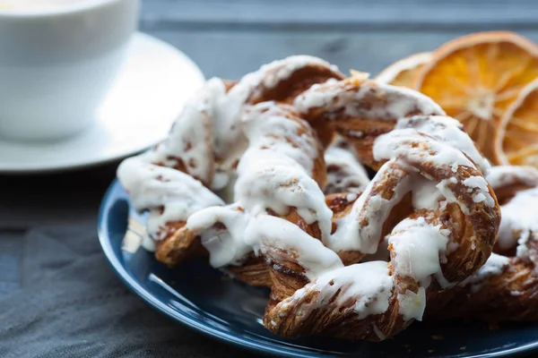 Ezilmiş fındık ve limon fondan mavi tabakta ile Bavyera kremalı pasta. Arka planda bir fincan çay ve kurutulmuş Portakal dilim