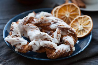 Ezilmiş fındık ve mavi bir plaka üzerinde kurutulmuş portakal dilimleri ile Bavyera kremalı pasta. Koyu arka plan.