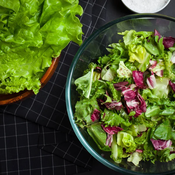 Verse vegetarische salade Meng in een kom helder glas op een zwarte achtergrond. — Stockfoto