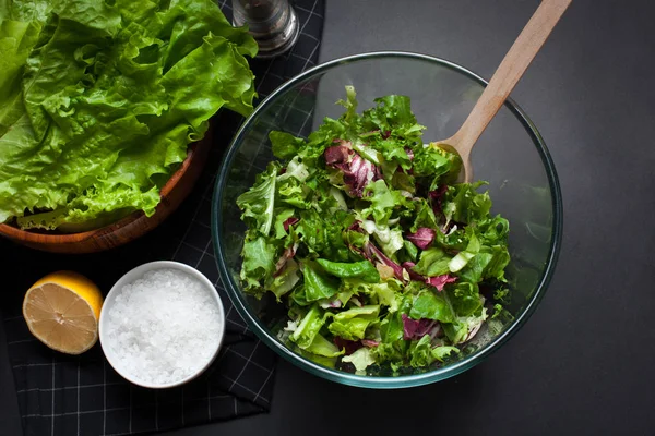 Verse vegetarische salade Meng in een kom helder glas op een zwarte achtergrond. — Stockfoto