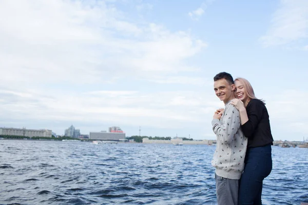 Jovem casal abraçando e sorrindo no fundo da paisagem urbana. Embarque fluvial em São Petersburgo — Fotografia de Stock