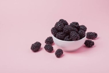 Taze Kırmızı Ahududu pembe bir arka plan üzerinde beyaz kase. Kopya alanı