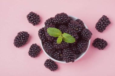 Taze Kırmızı Ahududu pembe bir arka plan üzerinde beyaz bir kase closeup. Üstten Görünüm.