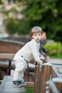 Bir bej kazak giymiş uzun saçlı sevimli sarışın çocuk portresi. Üç yaşında güzel bir çocuk