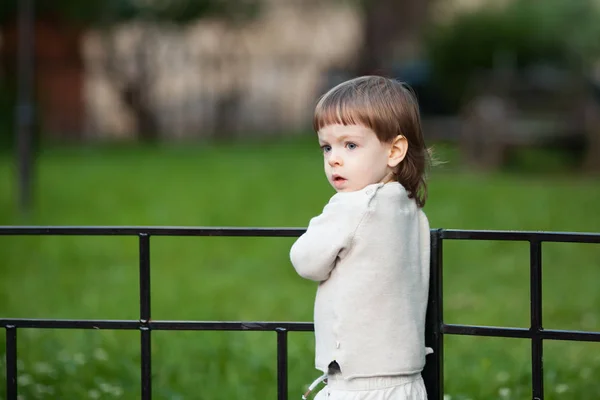 Retrato de un lindo niño rubio con el pelo largo, vestido con un suéter beige. Un hermoso niño de tres años — Foto de Stock