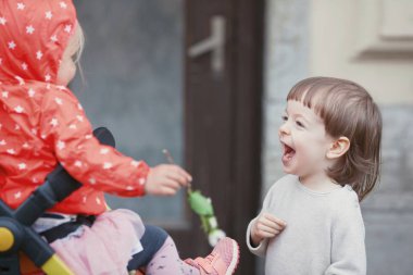 Uzun sarı saçlı küçük bir kız bebek arabası içinde oturan oynamaktan mutlu çocuk