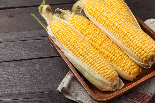 Taze mısır koçanı ahşap masa, tatlı, üstten görünüm üzerinde. Kopya alanı ile koyu arka plan