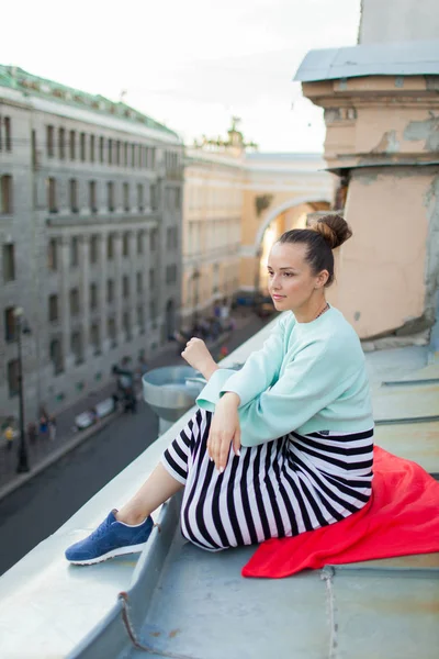 Menina solitária bonita sentada no telhado na cidade velha dos sonhos . — Fotografia de Stock