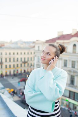 Evet ve eski şehir Evin çatısı üzerinde dururken gülümseyen gözlüklü şirin iş kadını.