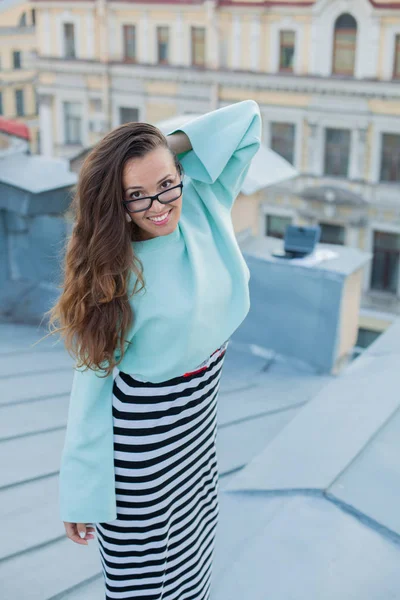 Portréja egy fiatal és gyönyörű lány, szemüvegek, aki sétál este a tetőn a régi város. A szabadság fogalma — Stock Fotó