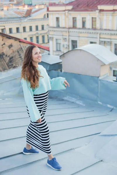 Akşam eski şehir çatıların üzerinde yürüyen güzel bir genç kız portresi. Özgürlük kavramı