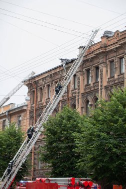 Saint Petersburg, Rusya Federasyonu, 13 Eylül 2017 sabahı. İtfaiyeciler sokak Çaykovski 31 konut binasının çatısında büyük bir yangın söndürmek