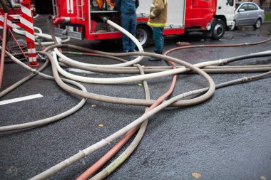 Arka planda yangın kamyon ve iş yerinde itfaiye Yangın hortumlar