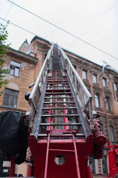 Gelişeceğini merdiven itfaiye arabası. İtfaiyeciler eski evin çatısı söndürmek