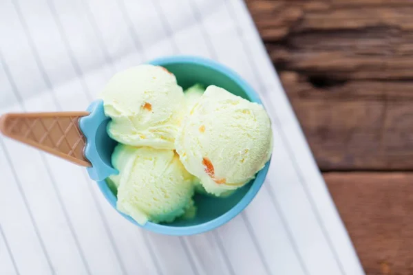 Vanilla ice cream with a taste of melon in a bowl on old wooden table. — Stock Photo, Image