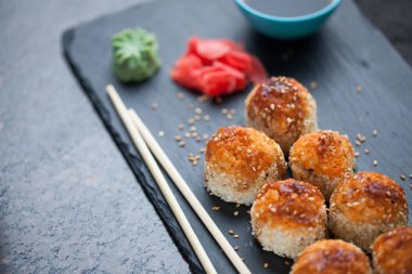 Japon mutfağı. Et ürünleri ve taş levha siyah granit zemin üzerine peynir pişmiş suşi. Üstten Görünüm