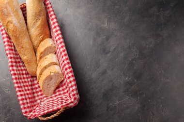 Ekmek bir hasır sepet içinde karanlık Taş Masa üzerinde dilimlenmiş. Yukarıdan kopya alanı ile göster