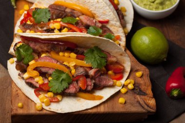 Mermer sığır eti, siyah Angus ve sebze eski rustik masada üç Meksikalı Taco. Soslar guacamole ve salsa kase ile Meksika yemek