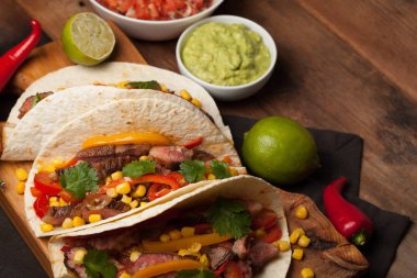 Mermer sığır eti, siyah Angus ve sebze eski rustik masada üç Meksikalı Taco. Soslar guacamole ve salsa kase ile Meksika yemek