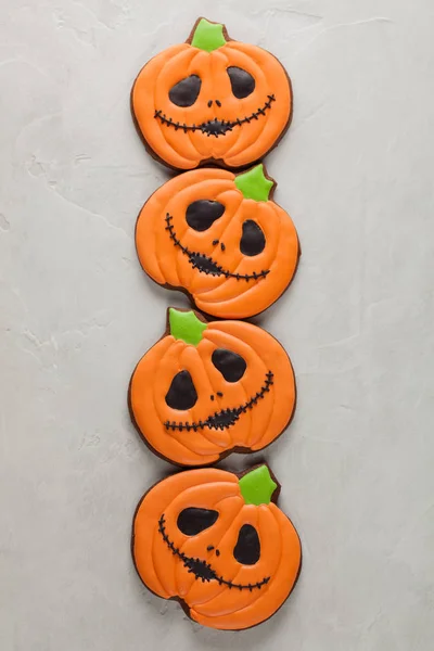 Homemade ginger cookies in the shape of pumpkins for Halloween. On the lighter concrete background. Top view — Stock Photo, Image