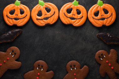 Cadılar Bayramı Balkabağı, gingerbread adam ve yarasalar çerezleri ek yükü kopya alanı ile vurdu. Karanlık beton arka plan üzerinde