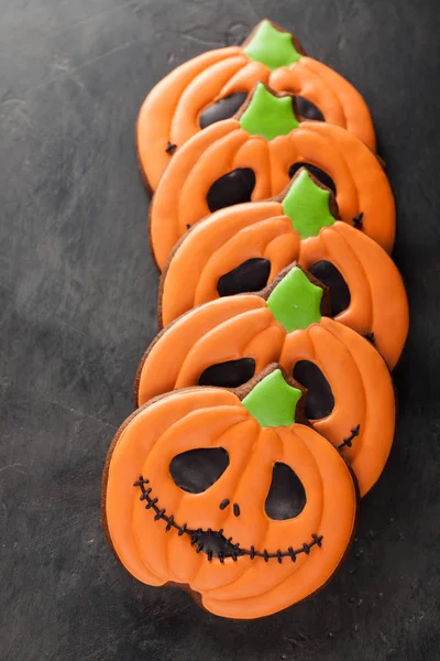 Homemade gingerbread cookies for Halloween in the form of pumpkins on dark concrete background. Top view — Stock Photo, Image
