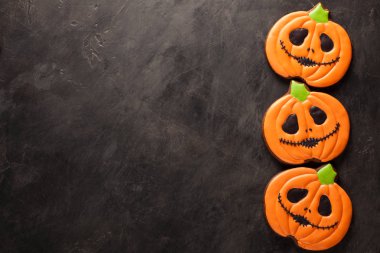 Ev yapımı gingerbread çerezleri için Halloween pumpkins kopya alanı karanlık beton zemin üzerine şeklinde. Üstten Görünüm