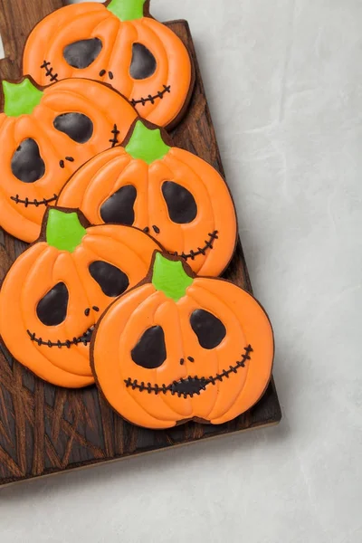 Homemade ginger cookies in the shape of pumpkins for Halloween. On the lighter concrete background. Top view — Stock Photo, Image