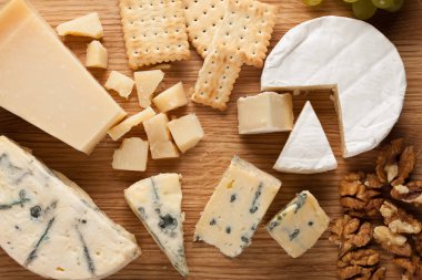 Ahşap plaka üzerinde peynir yemek tatma. Karanlık bir taş masada şarap ve romantik, peynir Şarküteri gıda. Üstten Görünüm