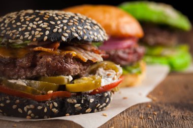 Üç mini dizi closeup ev yapımı Burger mermer sığır eti ve sebze ahşap oyun tahtası