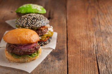 Üç mini dizi ev yapımı Burger mermer sığır eti ve sebze eski ahşap arka plan üzerinde. abur cubur ve fast food kavramı. kopya alanı ile