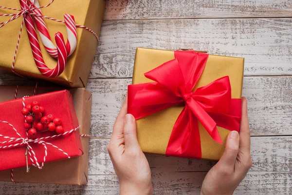 El yapımı dekorasyonu ile Noel hediyesi Beyaz ahşap zemin üzerinde tutan eller
