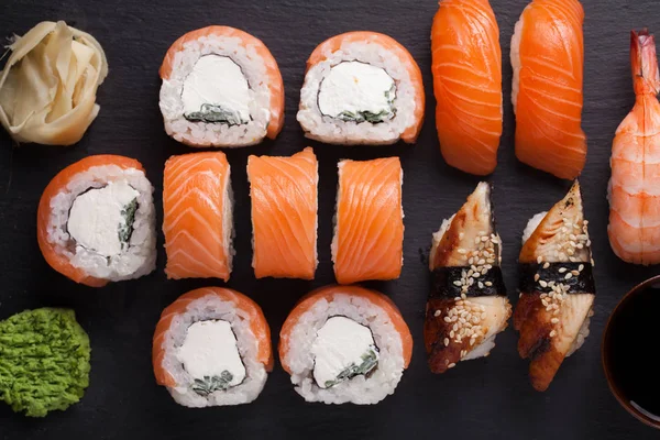 Közeli sushi beállítása sashimi lazac, garnéla, angolna és a sushi tekercs philadelphia szolgált a kő pala. Szemközti nézet — Stock Fotó