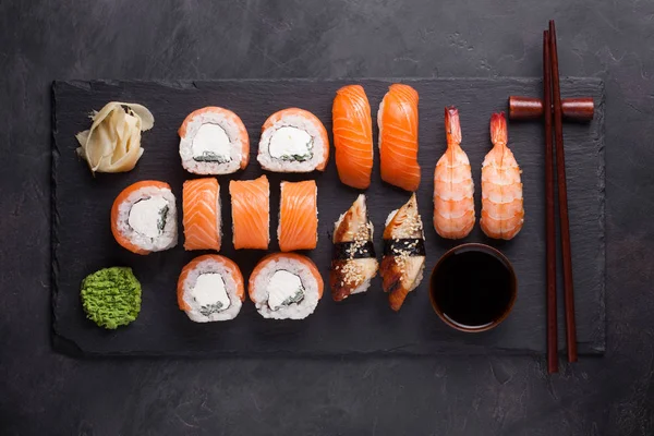 Sushi-Set Sashimi mit Lachs, Garnelen, Aal und Sushi-Rollen Philadelphia serviert auf Steinschiefer. Ansicht von oben. — Stockfoto