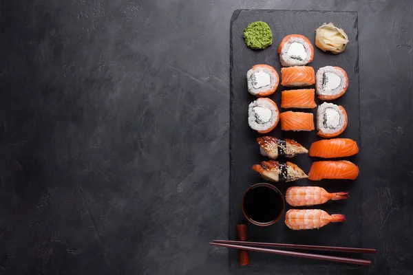 Sushi Set sashimi met zalm, garnalen, paling en sushi rolls die Philadelphia geserveerd op natuursteen leisteen. Bovenaanzicht met kopie ruimte — Stockfoto