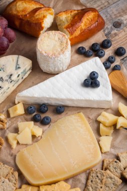 Ahşap plaka üzerinde peynir yemek tatma. Ahşap rustik masa üzerinde şarap ve romantik, peynir Şarküteri gıda. Üstten Görünüm