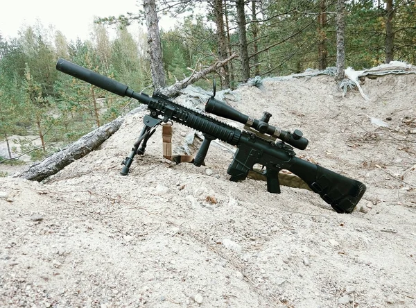 Rifle de asalto en el fondo de bosques de pinos y arena —  Fotos de Stock