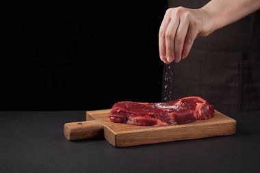 Sığır eti biftek ve arka plan metin tasarım veya logo menü Restoran için boş alan ile chef tarafından tuz. Gıda arka plan. Siyah metin alanı. Kopya alanı