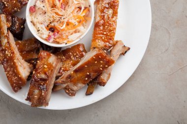 Barbekü sosu ve bal ile lahana beyaz plaka üzerinde domuz kaburga ızgara. Taş Masa lambası, üstten görünüm bira için snack