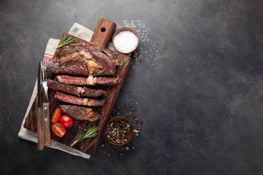 Kırmızı şarap, otlar ve baharatlar karanlık bir taş zemin üzerine antrikot biftek biftek ızgara. Metniniz için kopya alanı ile Üstten Görünüm