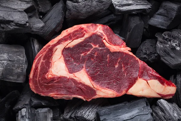 Carne fresca cruda Bistecca Ribeye su fondo nero carbone — Foto Stock