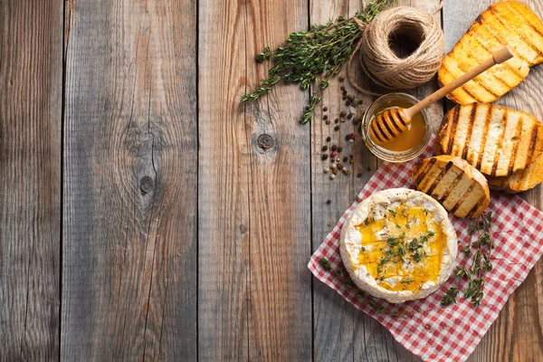 Skutečnou Camembert z Francie s tymiánem, medu a toastový chléb na starý dřevěný rustikální stůl. Měkký sýr na dřevěnou pozadí s kopie prostoru. Pohled shora — Stock fotografie