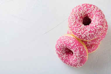 Çörek. Tatlı krema şeker yiyecek. Tatlı renkli aperatif. Sırlı sprinkles. Lezzetli pasta kahvaltı tedavi. Ekmek pasta. Halka buzlanma ile. Sağlıksız yuvarlak pişmiş. Kopya alanı ile Üstten Görünüm