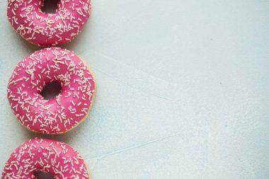 Çörek. Tatlı krema şeker yiyecek. Tatlı renkli aperatif. Sırlı sprinkles. Lezzetli pasta kahvaltı tedavi. Ekmek pasta. Halka buzlanma ile. Sağlıksız yuvarlak pişmiş. Kopya alanı ile Üstten Görünüm