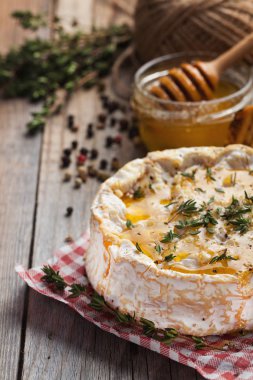 Gerçek bir Camembert kekik, bal ve eski ahşap rustik masa üzerinde kızarmış ekmek ile üzerinden. Yumuşak peynir bir ahşap zemin üzerinde. Üstten Görünüm