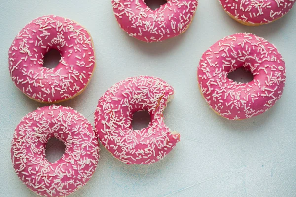 Bitten donut. Sweet icing sugar food. Dessert colorful snack. Glazed sprinkles. Treat from delicious pastry breakfast. Bakery cake. Doughnut with frosting. Baked unhealthy round