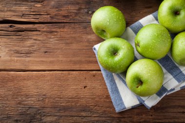 Eski rustik masa ahşap bir kasede olgun yeşil elma. Ahşap arka plan üzerinde yararlı meyve. Kopya alanı ile Üstten Görünüm